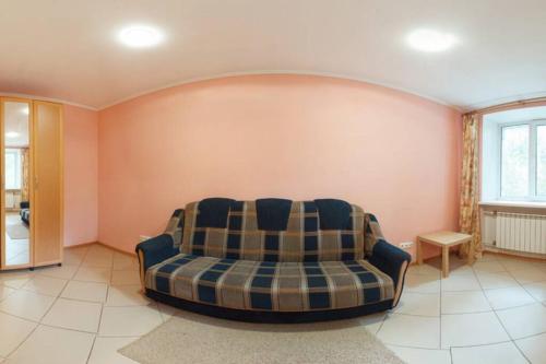 a living room with a couch in a room at Двухкомнатная посуточно на проспекте К-Маркса, 30 in Omsk