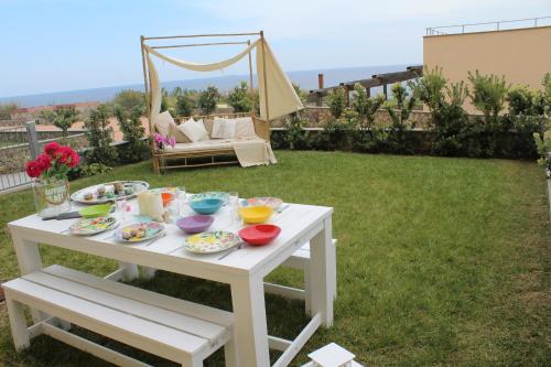a white table with food on it in a yard at Cluxury-Torre dei Saraceni BOUTIQUE APT BY THE SEA Beach, Pool,Private Jacuzzi, Parking in Cervo