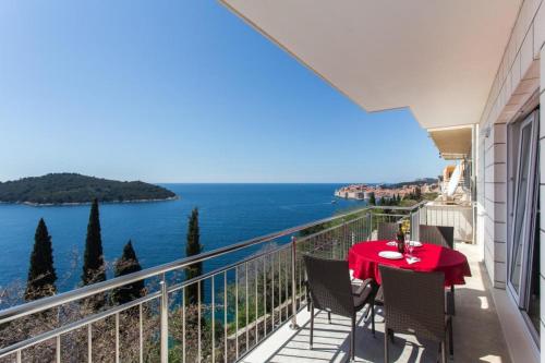 balcón con mesa, sillas y vistas al océano en Apartments Villa Ari, en Dubrovnik