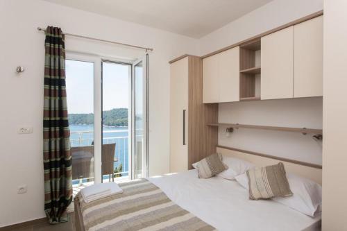 1 dormitorio con cama y ventana grande en Apartments Villa Ari, en Dubrovnik