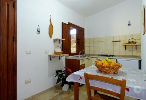 a kitchen with a table with a basket of fruit on it at Casa Museddu in Cardedu