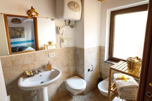 un bagno con lavandino, WC e specchio di B&B La Corte San Francesco a Bari