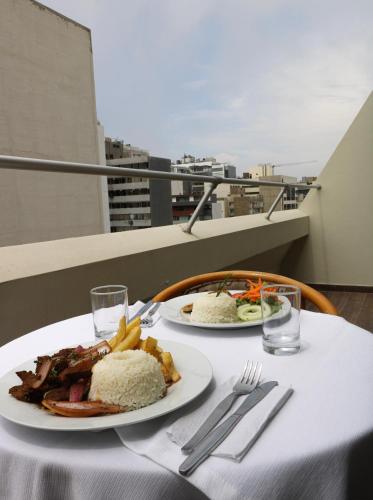 a table with two plates of food on a balcony at Hotel Miramar in Lima