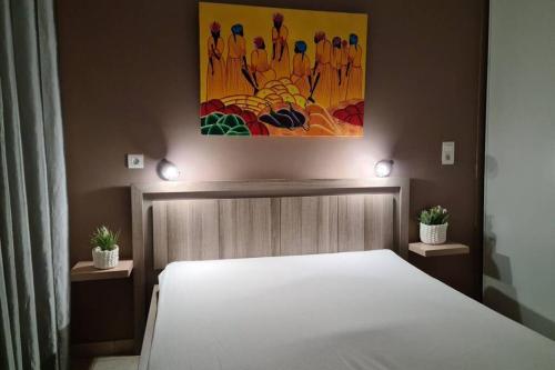 une chambre avec un lit et un tableau au mur dans l'établissement Home Charmant des Alpilles, à Saint-Étienne-du-Grès