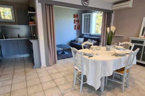 une salle à manger et une cuisine avec une table et des chaises dans l'établissement Home Charmant des Alpilles, à Saint-Étienne-du-Grès