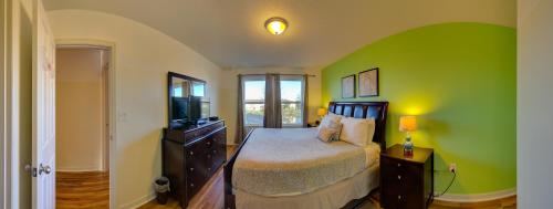 a bedroom with a bed and a green wall at 4 Bedroom SunHaven Townhouse with Pool Near Disney in Kissimmee