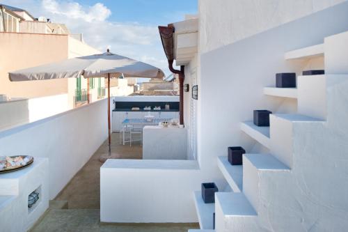 a white house with white stairs and an umbrella at La Casa Dell'Arancio in Favignana