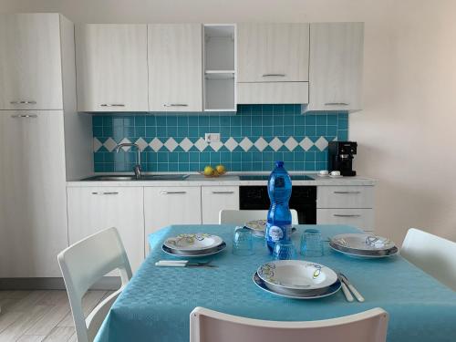 a kitchen with a table with a blue table cloth at Le ciliegie: appartamento moderno Isola Rossa in Isola Rossa