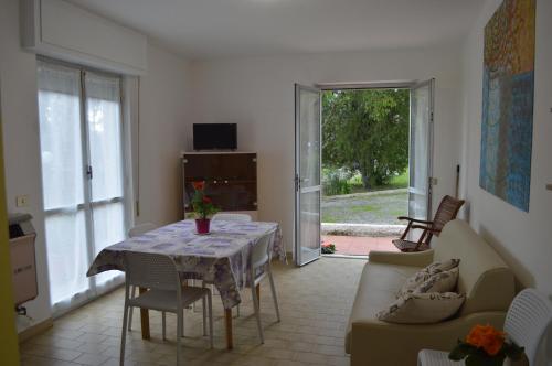 sala de estar con mesa y sofá en Le Villette di Villa Paola en Loano