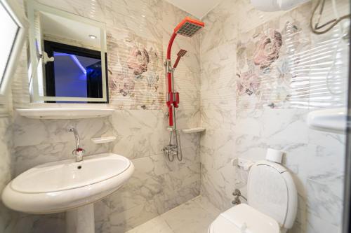een witte badkamer met een wastafel en een toilet bij Gardenia Pyramids view inn in Caïro