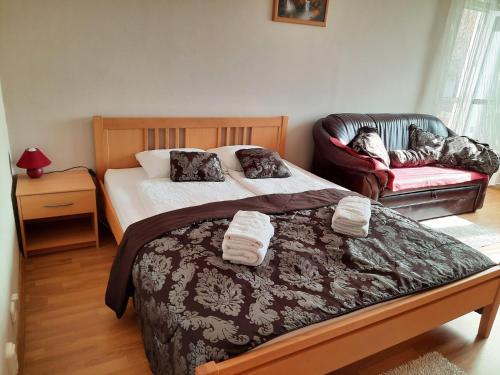 a bedroom with a large bed and a couch at Sétány apartman in Mórahalom