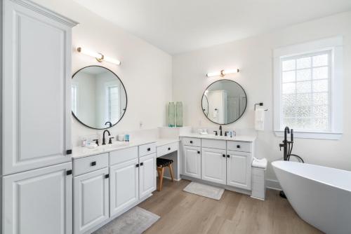 a white bathroom with two sinks and a tub and mirrors at 248 Beach Bike Way in Inlet Beach