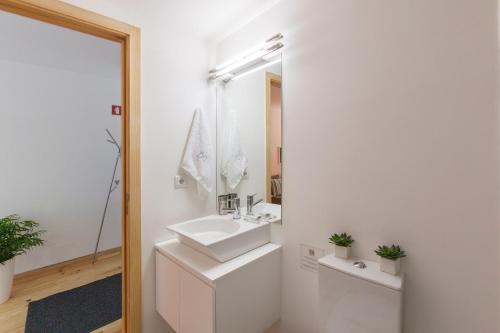 a white bathroom with a sink and a mirror at BO - Almada in Porto