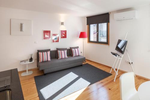 a living room with a couch and a television at BO - Almada in Porto