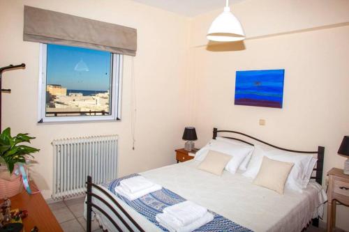 a bedroom with a bed and a window at City & beach apartment I in Rethymno in Rethymno