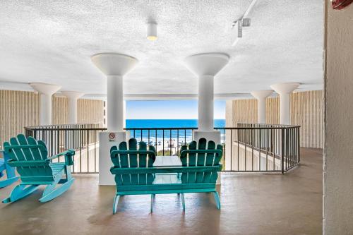 a balcony with chairs and a view of the ocean at The Top of the Gulf #612 in Panama City Beach