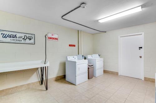 a laundry room with two washers and a sink and a door at The Top of the Gulf #612 in Panama City Beach