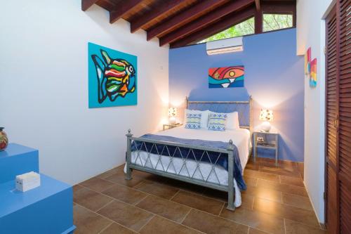 a bedroom with a bed with blue walls at Hotel Casa Leona in Tamarindo