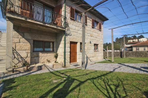 a large stone house with a balcony and a yard at Casa da Fatinha by Gerês Casas in Terras de Bouro