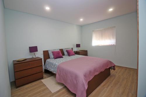 een slaapkamer met een bed, een dressoir en een raam bij Casa da Fatinha in Terras de Bouro