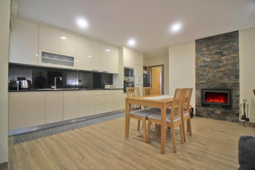 a kitchen with a table and chairs and a fireplace at Casa da Fatinha by Gerês Casas in Terras de Bouro