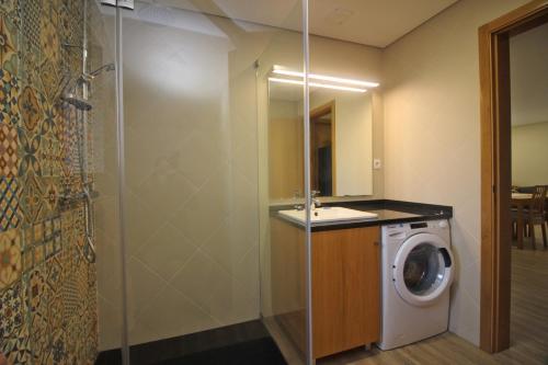 a bathroom with a washing machine and a mirror at Casa da Fatinha by Gerês Casas in Terras de Bouro
