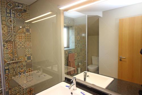 La salle de bains est pourvue d'un lavabo et d'un miroir. dans l'établissement Casa da Fatinha, à Terras de Bouro