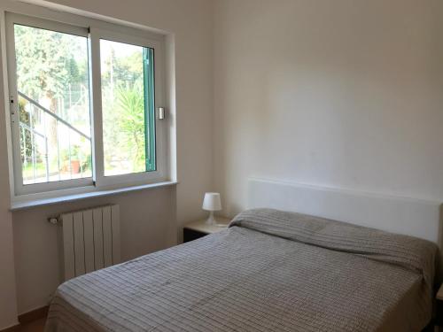 a bedroom with a bed and a window at Le Villette di Villa Paola in Loano