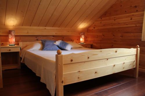 ein Schlafzimmer mit einem Bett in einer Blockhütte in der Unterkunft Bouleau in Vresse-sur-Semois