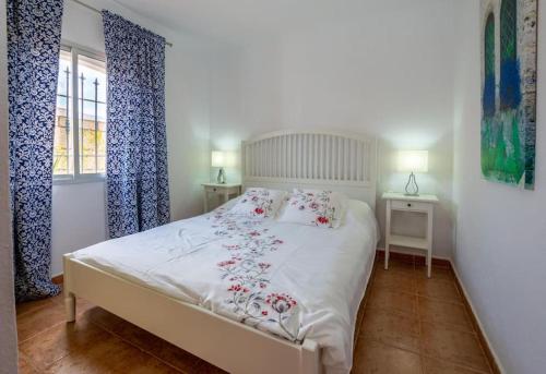 1 dormitorio con 1 cama blanca y 2 ventanas en Villa Iris, en Callao Salvaje