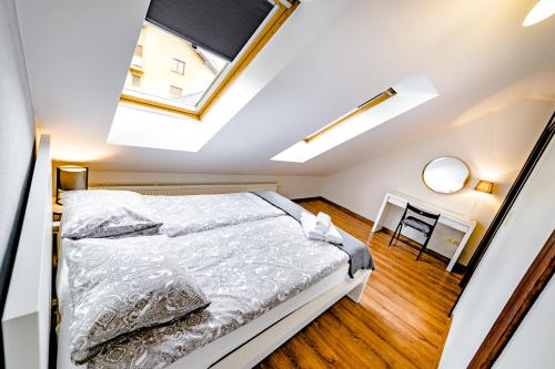 a attic bedroom with a bed and a desk at Apartament Stylowy in Leszno