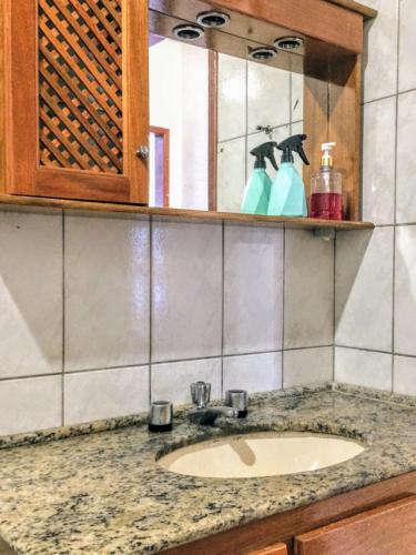 a bathroom counter with a sink and a mirror at Duque Hostel in Florianópolis