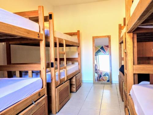 a room with several bunk beds and a mirror at Duque Hostel in Florianópolis
