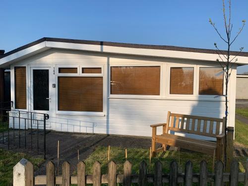 un remolque blanco con un banco delante de él en Dartmouth 2 Bed Detached Chalet 144 Norton Park, en Dartmouth