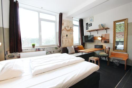 a bedroom with a large white bed and a desk at Aappartel City Center - kontaktloser Check-in 24h in Bielefeld
