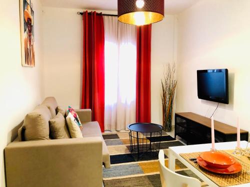 a living room with a couch and a tv at Apartamento La Habana Vieja in Jerez de la Frontera