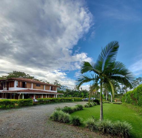 a palm tree in front of a house at Casa Campestre Sol Y Luna in Quimbaya