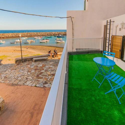 a balcony with a table and a view of the beach at Beach House Tajao in La Jaca