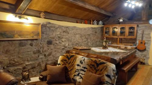 ein Wohnzimmer mit einem Sofa und einer Steinmauer in der Unterkunft Stone House in Vila Real