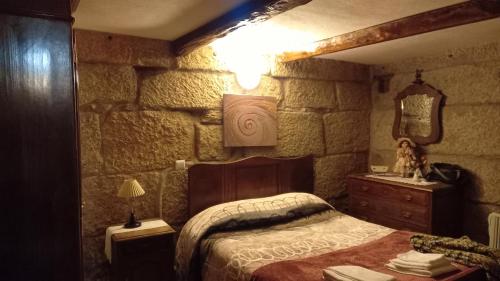 Schlafzimmer mit einem Bett, einer Kommode und einem Spiegel in der Unterkunft Stone House in Vila Real
