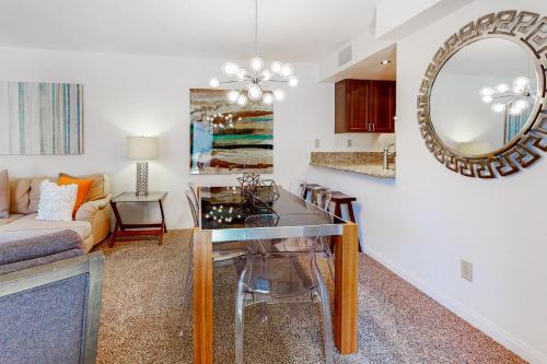 a living room with a table and a mirror at Caballeros Condo in Palm Springs