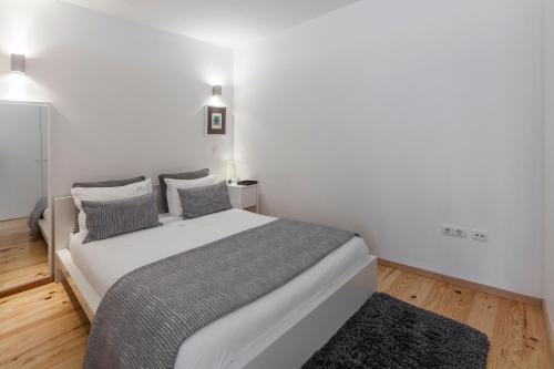 a bedroom with a large white bed with two pillows at BO - Almada in Porto