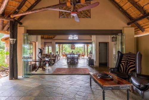 an open living room with a ceiling fan at Shumbalala Game Lodge in Thornybush Game Reserve