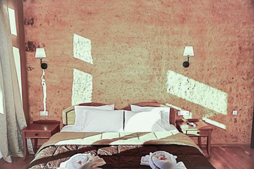 a bedroom with a bed with two tables and two lamps at Santrivani Rooms in Chania