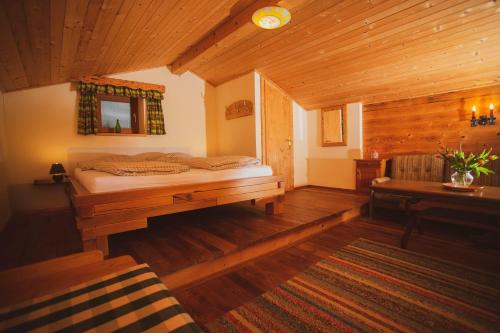a bedroom with a bed in a wooden cabin at Lesachtalerhof in Liesing