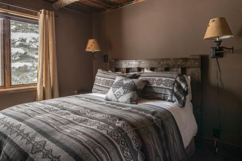 a bedroom with a bed with pillows and a window at Hobbit House in Big Sky