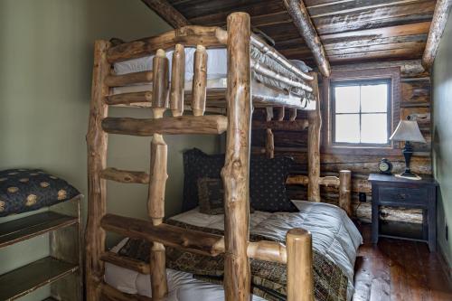 a bedroom with two bunk beds in a log cabin at Hobbit House in Big Sky