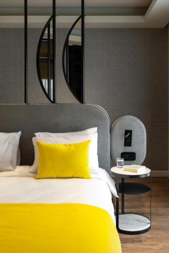 a bedroom with a yellow bed and a mirror at COLORS Hotel Athens in Athens