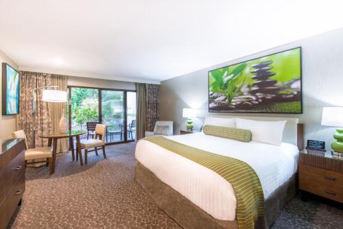 um quarto de hotel com uma cama grande e uma mesa em The Creekside Inn em Palo Alto