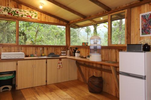 a kitchen with wooden walls and a white refrigerator at Mindo Eco Suite con Rio y Cascada in Mindo